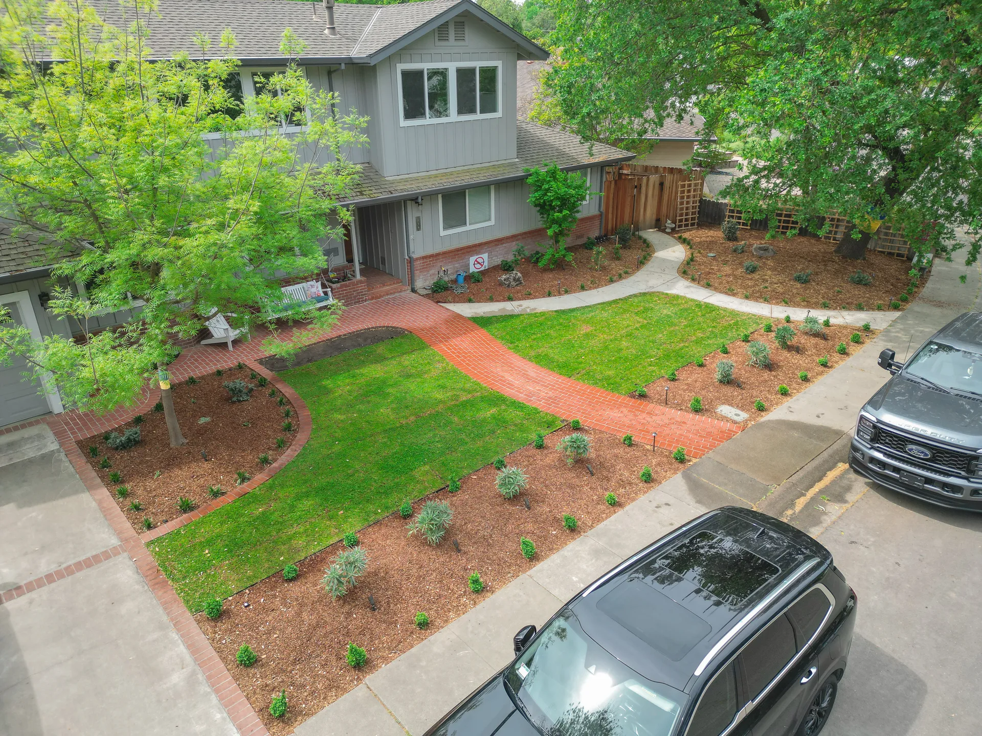 Front yard landscape installation with brick walkway, sod, mulch, and new plantings in Sacramento